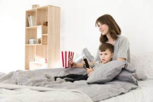 Madre e hijo cama viendo tv_23 2148443191