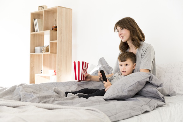 Madre e hijo cama viendo tv_23 2148443191