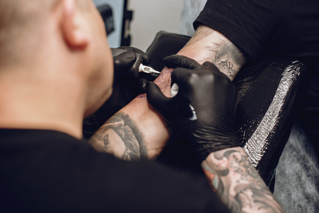 Hombre haciendo tatuaje salon tatuajes 1